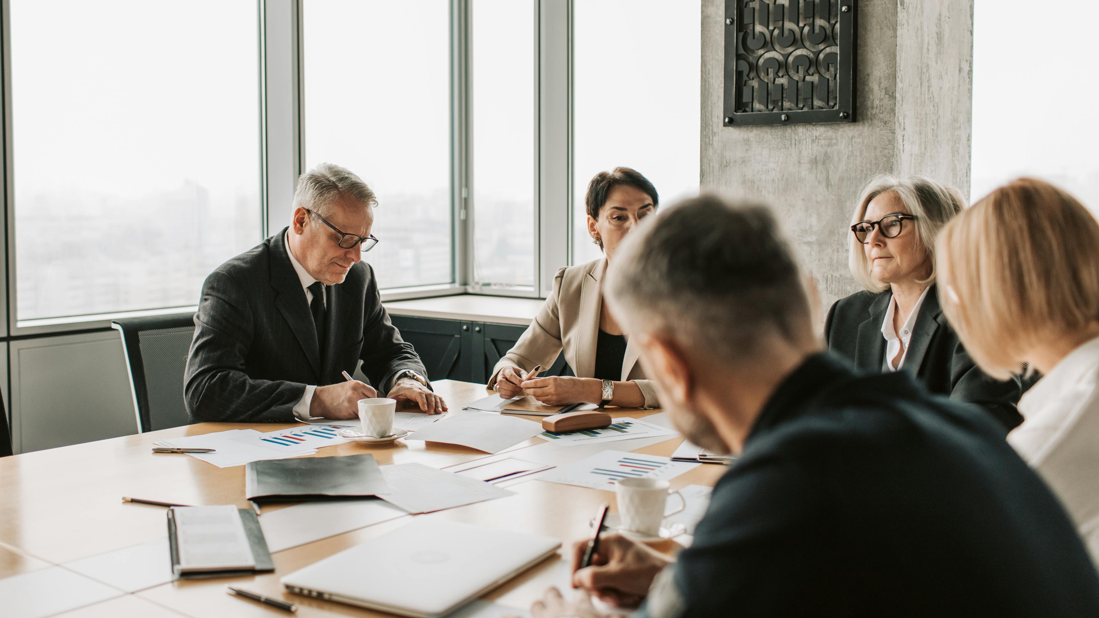 Professional handshake across a boardroom table, illustrating securing business funding